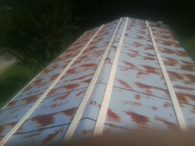 Rusted metal roof panels with new wood purlins before replacement — Storm Damage Roof Repair in Osakis by Roofing Brothers