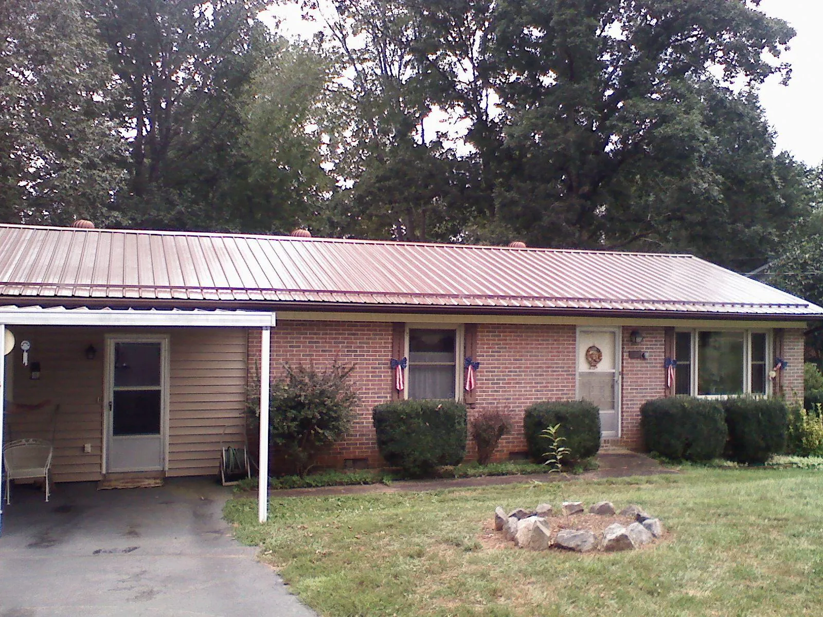 Bronze metal roof and carport on a brick ranch home — Roof Repair work by our crew in Osakis